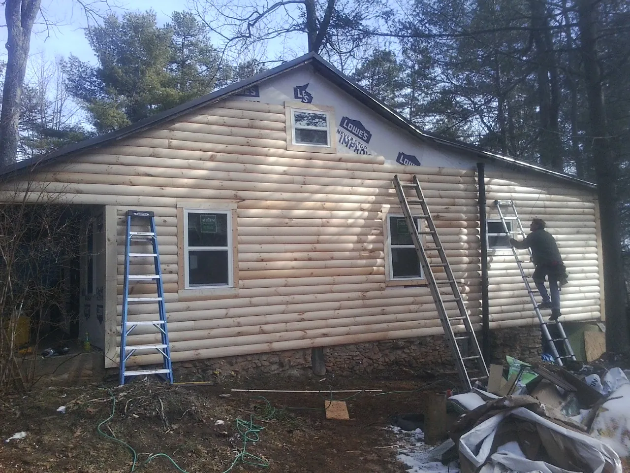Ladders set against fresh log siding during an exterior remodel in Van Nuys