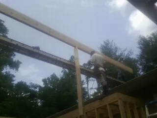 Carpenter setting a ridge beam over a new addition frame — Ice Dam Removal by Roofing Brothers in Van Nuys